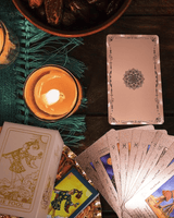 The Witch's Cauldron Rose Gold Tarot Card Set includes a guide booklet and is suitable for beginners. It features information on chakras, planets, zodiac signs, elements, and affirmations.